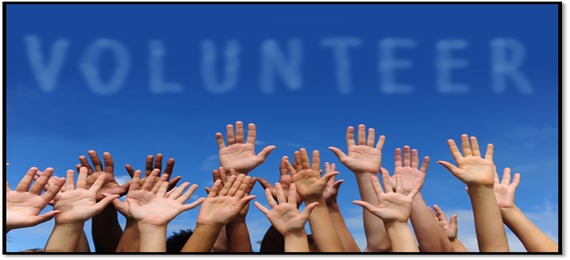 volunteer spelled in the sky as clouds; many multi ethnic hands raised