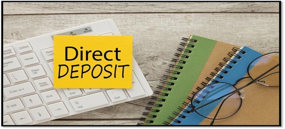 desk with white keyboard with a yellow sticky on it that reads Direct Deposit. There are two notebooks next to it with glasses on top