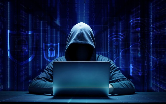 Hooded hacker online security on laptop