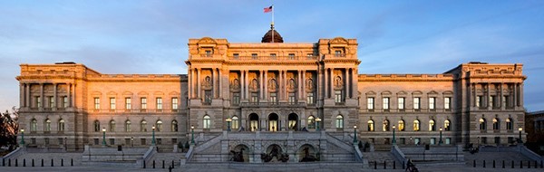 A panoramic shot of the Library of Congress with the sun setting in the background