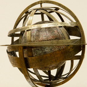 A globe is encircled by interlocking rings that illustrate the rotation of the sun, moon and stars.