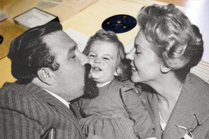 Doc Pomus gives his young daughter, Sharyn Felder, a kiss on the cheek as his wife, Wilma Burke, holds the child and looks on, smiling.