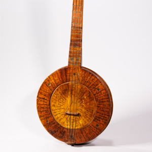 A close up of a wooden banjo is covered in intricate signatures of folk musicians and scholars. Photo by Shawn Miller
