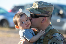 A soldier gives his eight-month-old son goodbye