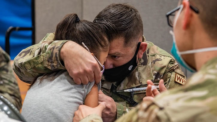 Parent comforting a child receiving COVID vaccine