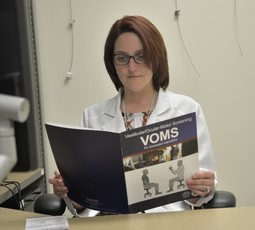 DVIDS photo of provider reviewing the VOMS guide from TBICoE.