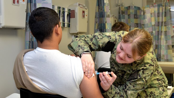 Service member vaccinates a patient