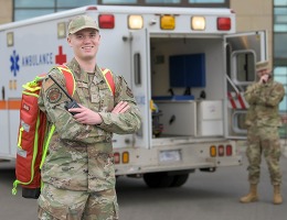 Air Force emergency medical technician stands in front of an ambulance