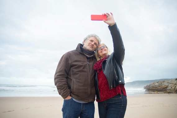 Man and woman take a selfie on the beach.