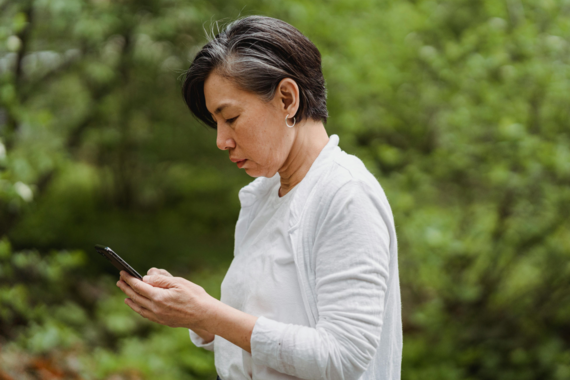 Older Asian woman looks at cell phone