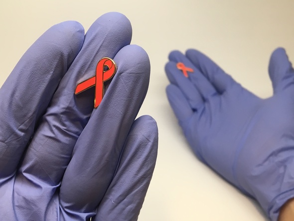 gloved hands with AIDS awareness ribbons