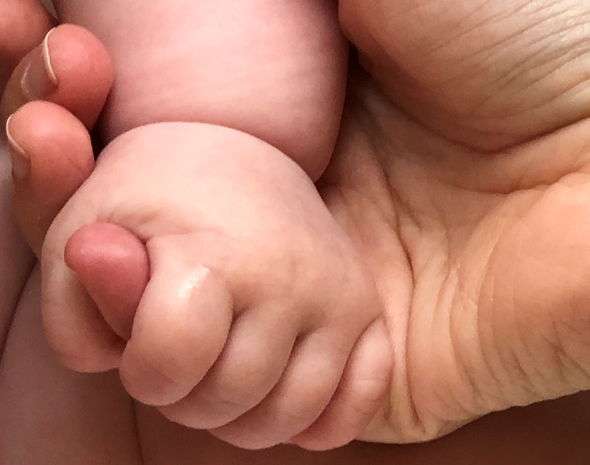 Baby's hand holding woman's finger