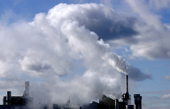 White cloudy air emissions emerge from a factory complex