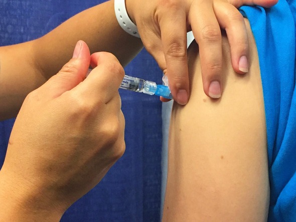 Close-up photograph of a person receiving a flu shot. 