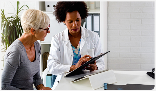 Health care professional reviewing chart with patient