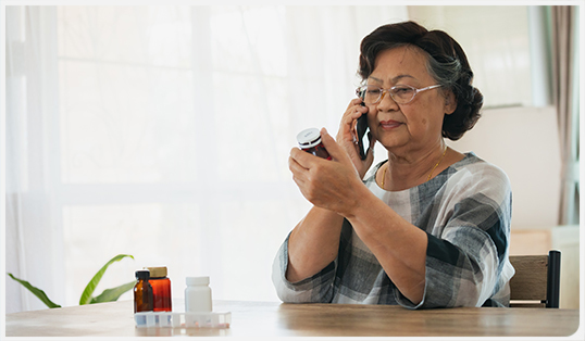 Woman on the phone while looking at medication label