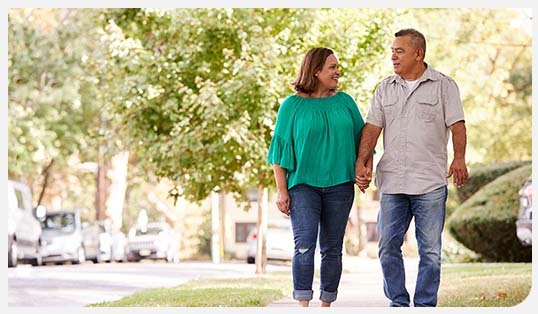 A man and woman walking on a sidewalk