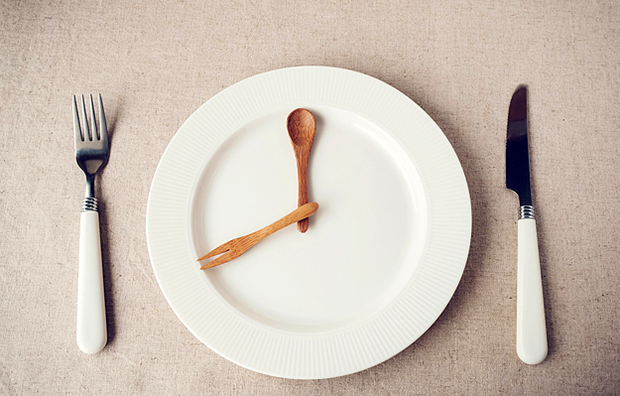 A plate with a knife and fork representing the hands of a clock.