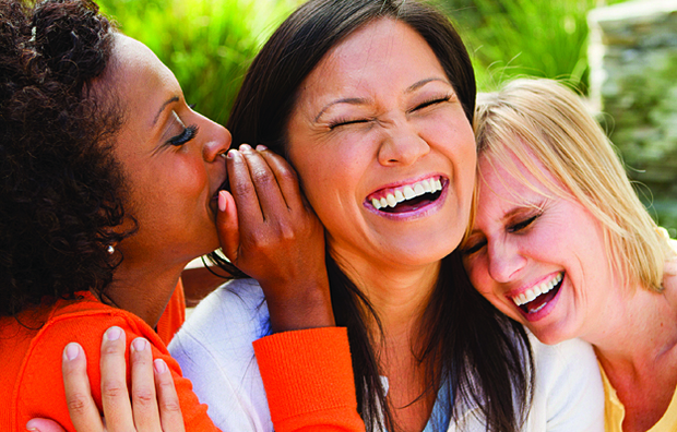 Three women laughing together.