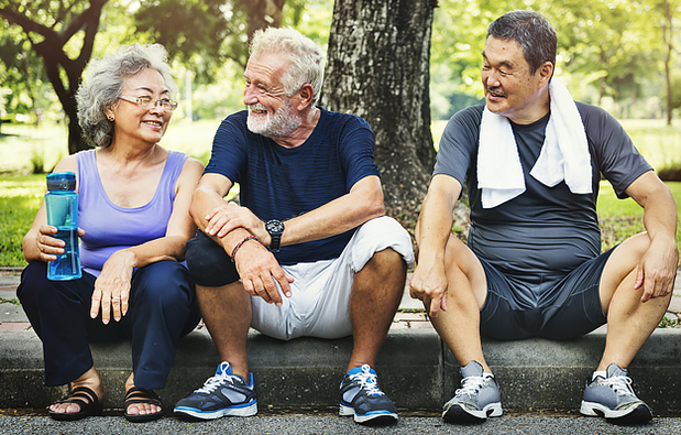 Three mature adults resting after exercising together.