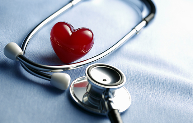 A plastic heart with a stethoscope around it.