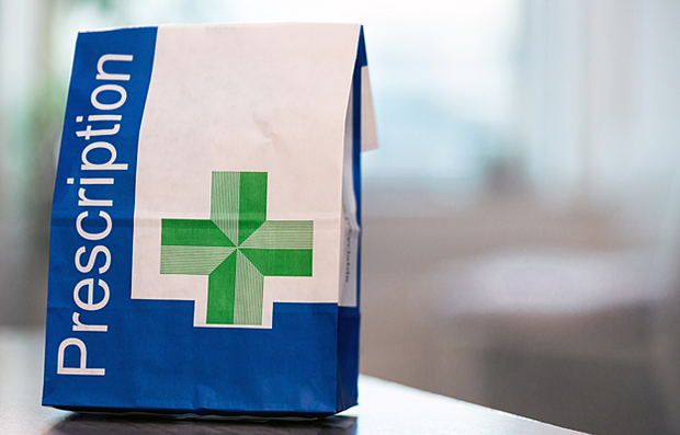 A paper bag with "Prescription" and a green cross on it.