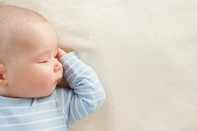 Photo of baby sleeping on blanket, associated with May 2019 research spotlight article on Scientists identify early visual attention deficits in infants at risk for autism spectrum disorder.