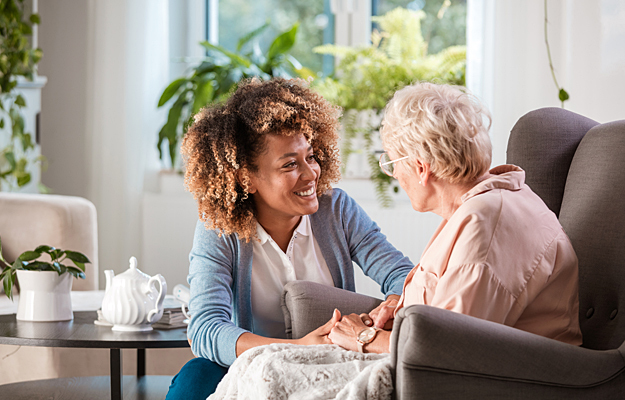 A caregiver assisting a senior woman in her home.