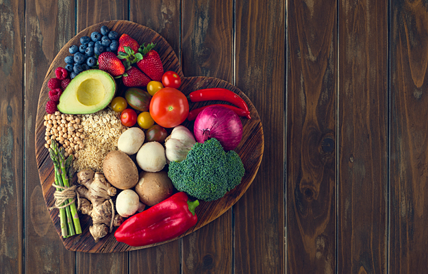 An assortment of healthy foods on a heart shaped plate.