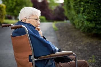 Senior man man sitting in a wheelchair outside