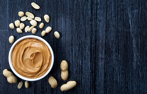 Peanuts and a bowl of peanut butter.