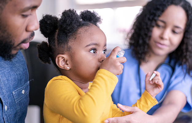 A young girl using an asthma inhaler.