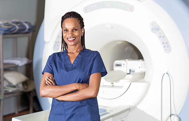 A radiologist standing in front of an MRI machine.