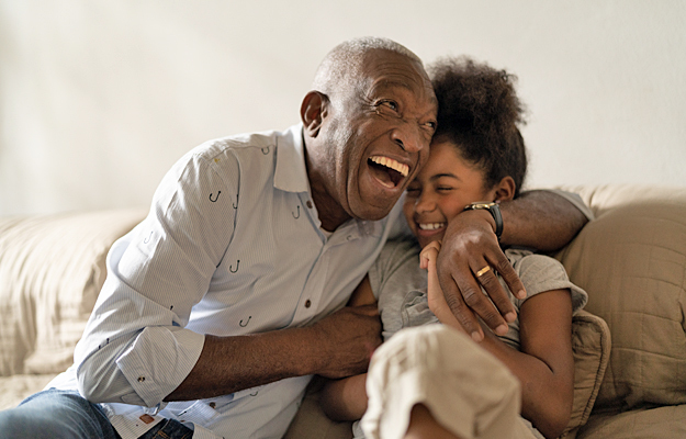 A grandfather and granddaughter laughing together.