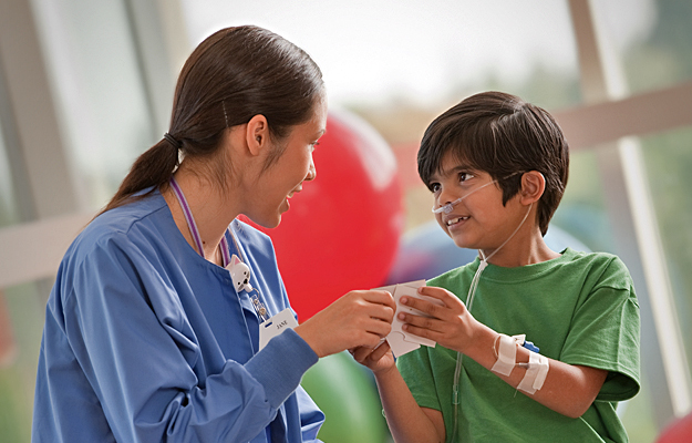 A doctor interacting with a young patient in the hospital.