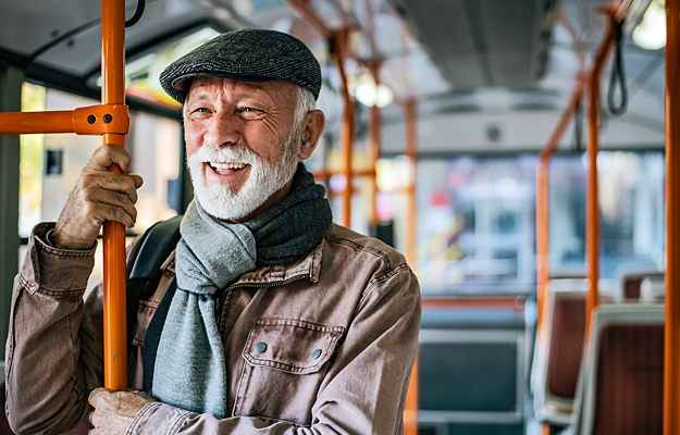 A senior man riding a public bus.