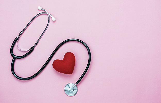 A stethoscope wrapped around a plush red heart.