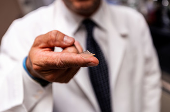 Researcher holding microneedle array on fingertip