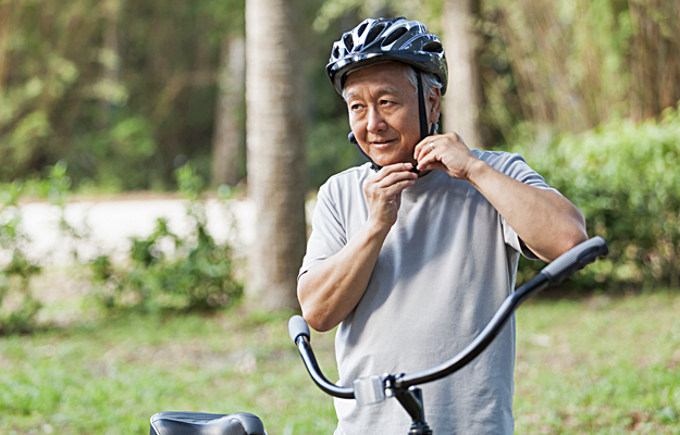 A senior man fastening a bicycle helmet strap.