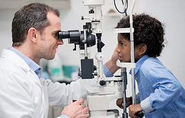 A young boy getting an eye exam.