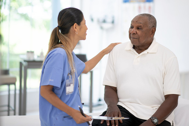 A senior African American man talking to his doctor.