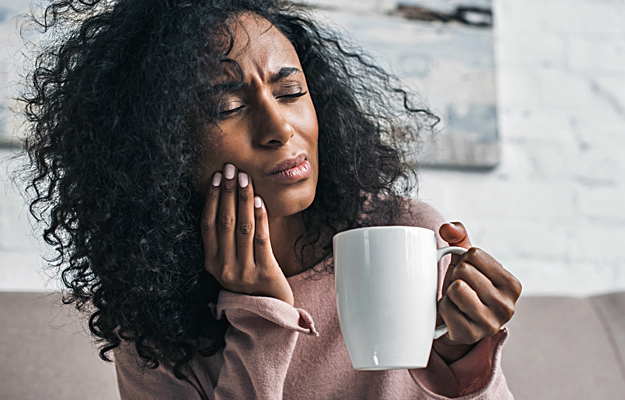 A woman holding her jaw in pain.