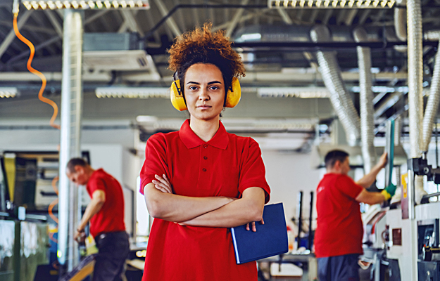 A woman at work wearing protective earmuffs.