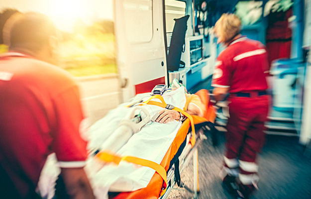 A rescue team bringing a person to an ambulance.