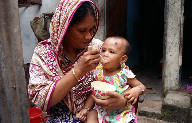 A mother feeding a young child.
