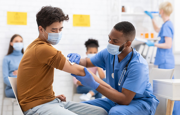 A young man getting vaccinated against coronavirus in a hospital.