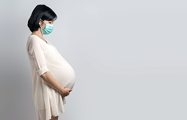 A pregnant woman wearing a face mask.