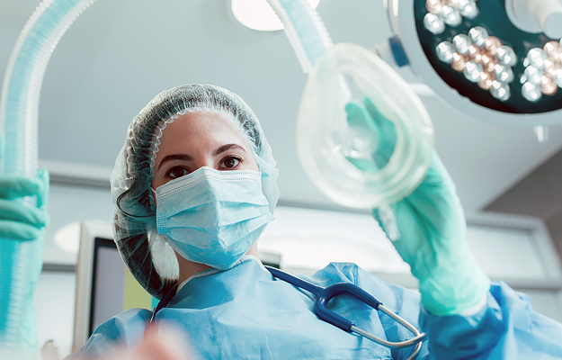 A doctor holding an anesthesia face mask.