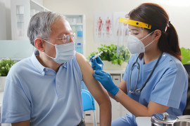 Nurse giving vaccination to senior person