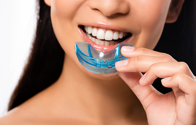 A close-up of a woman putting in her mouthguard.